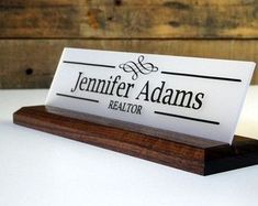 a business card holder on top of a wooden stand with a name tag attached to it