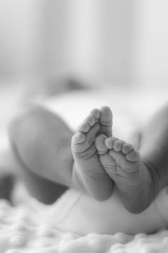 a black and white photo of a baby's feet