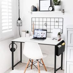 a white desk topped with a laptop computer next to a chair and potted plant