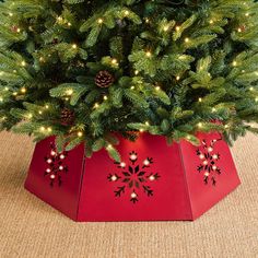 a christmas tree in a red box with lights on the top and snowflakes