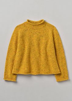 a child's yellow sweater on a gray background, with the top half turned down