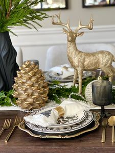 a christmas table setting with gold deer figurines