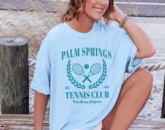 Palm Springs Tennis Club t-shirt. These tees are Comfort Colors and are made to last using premium ringspun cotton, this creates an vintage-soft shirt. The soft-washed, garment-dyed fabric brings extra coziness to your wardrobe while the relaxed fit makes it an excellent daily choice. ✦ 100% Ringspun Cotton ✦ Color: White, Chambray, Ivory, Butter, Blossom ✦ Relaxed fit ✦ Medium fabric ✦ Sewn-in twill label ✦ Eco-friendly, Ethically Made & Sweatshop Free ✦ Printed to order with non-toxic ink ✦ Durable and Long-lasting ✦ Shirts are pre-shrunk but may shrink slightly after washing ✦ Made to order: *Please allow 2-5 business days to print before being shipped* Sizing Recommendation: ✦ See size guide in images above ✦ This is a unisex t-shirt. Order your usual size for a relaxed fit, size down Sporty Tops With Sublimation Print For Spring, Sporty Spring Shirt With Letter Print, Sporty Crew Neck Spring Shirt, Sporty Crew Neck Shirt For Spring, Spring Sporty Shirt With Text Print, Sporty Shirt With Text Print For Spring, Sporty Spring Shirt With Text Print, Palm Springs Tennis Club, Preppy Shirt