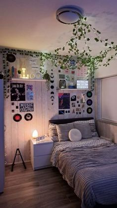 a bed sitting in a bedroom next to a wall with pictures and plants on it