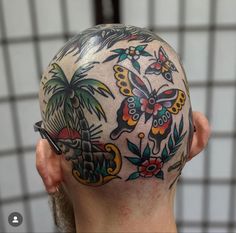 a man with a tattoo on his head has a palm tree and butterflies on it