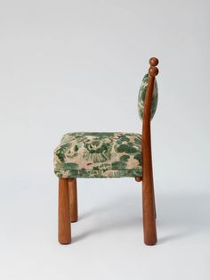 a wooden chair with a floral upholstered seat and back rest, on a white background