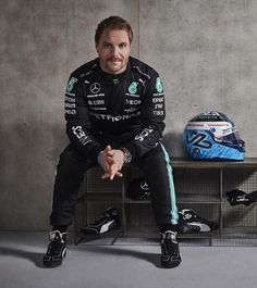 a man sitting on top of a bench next to a helmet