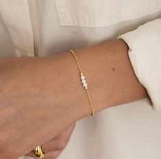 "A beautiful and elegant pearl bracelet featuring 3 dainty pearls. This bracelet is great for stacking or worn on its own for a delicate and minimalist look! Also makes a great gift for bridesmaids! - - - D E T A I L S - - -  * Made of 925 Sterling Silver * THICK plating of 14k Gold or Rhodium for a piece that is made to last! * Available in 6.25\" or 6.75\" + .5\" extension chain  * Made of the highest quality imitation pearls for an authentic look  * Nickel-free & Hypoallergenic  * Pearl Size: 3.5mm  * Lobster Clasp Closure  Made with 100% Pure Love! ♡ Comes in a gift-box, ready for gift-giving! 🎁 Ships same day! ✈️ For fast delivery! 🚀 Happy to answer any questions you may have! 🥰 Bracelets on Model: https://www.etsy.com/listing/1388390032/gold-bracelet-chain-bracelet-dainty?click_ke Dainty Pearl Bracelet, Pearl Bridal Jewelry, Bracelet Pearl, Bracelet Dainty, Jewelry Pearl, Dainty Bracelet, Pearl Bridal, Simple Bracelets, Bracelet Chain