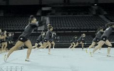 a group of women in black shirts and shorts are running on a court with tennis racquets