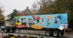 a large trailer with people on it driving down the road