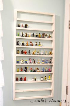 a white shelf filled with small toy figurines on top of it's sides