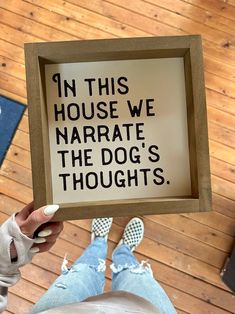 a person holding up a sign that says in this house we narrate the dog's thoughts