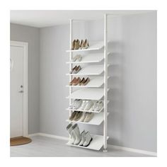 a white shoe rack with several pairs of shoes on it in the corner of a room