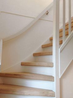 a white staircase with wooden handrails in a home