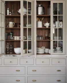 a white china cabinet filled with lots of dishes