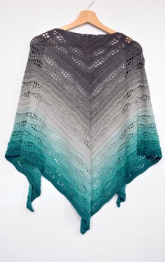 a crocheted shawl hanging on a hanger