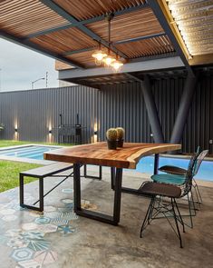 a wooden table sitting under a roof next to a swimming pool