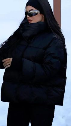 the woman is wearing a black coat and sunglasses