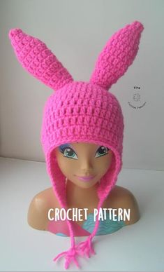 a pink crocheted hat with ears on top of a mannequin head