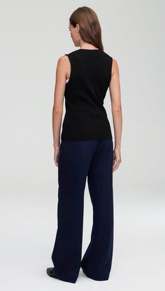 Elevate your workwear with a classic knit rib waistcoat. Designed to be worn as a top on its own or styled over a shirt or blouse, our waistcoat reimagines traditional suiting for the modern working woman. The slim silhouette features an all over ribbed pattern, a fitted v-neck silhouette, and button closure. Wear with relaxed trousers and sneakers for a cozy yet put-together ensemble. Classic Cotton Sweater Vest For Work, Chic Cotton Sweater Vest For Work, Versatile Cotton Vest For Work, Elegant Cotton Knit Top For Work, Sleeveless Knit Top For Fall Workwear, Versatile Knit Top For Work, Versatile Cotton Knit Top For Work, Stretch Knit Top For Work, Versatile Fitted Sweater Vest For Work