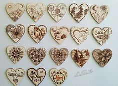 a bunch of heart shaped wooden magnets on a white surface