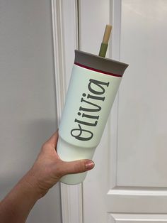 a person holding a cup with the word giving on it in front of a door