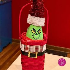 a basket with an angry grin face in it and a santa hat on the top