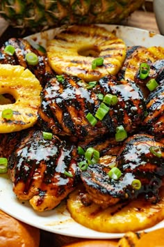 grilled pineapples and bananas on a white plate with green onion garnishes