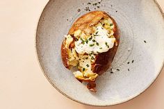 an open faced sandwich on a plate with sour cream and chives sprinkled on top