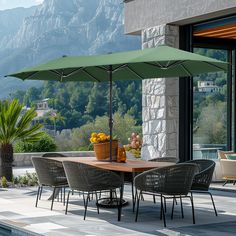 an outdoor table with chairs and umbrella next to a swimming pool