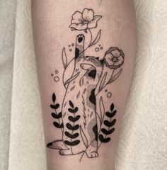 a black and white tattoo of a dog with flowers on it's leg,