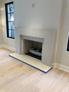 an empty living room with a fireplace and hardwood floors