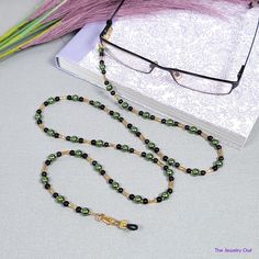 This jade green and black beaded chain will keep your glasses within reach, while adding a pop of color to your look. Just attach it to your glasses and you can have the peace of mind that your glasses will be with you wherever you go! The perfect gift for those who tend to misplace their glasses. Rubber loops adjust to fit most glasses frames. Lightweight and comfortable fit.   🦉Product Details:  * Approx. Length - 31 in (including rubber loops) * Chain Weight: 0.7 oz * Bead Color(s): Jade Green, Black, Gold * Metal Color: Gold-tone * Material: Glass pearls and Beads, bugle Beads * Closure: Lobster Claw Clasps and Rubber Loop Ends * Product ID: G171 🎁 Gift packaging available at Checkout ($4.00 USD) - See last image   🦉NOTES: * Not recommended for young children! * The lobster clasps m Black Glass Beaded Necklaces With Beaded Chain, Black Glass Beaded Necklace With Beaded Chain, Black Glass Beaded Necklace, Handmade Green Glasses Chains With Round Beads, Black Beaded Glasses Chain With Round Beads, Black Beaded Glasses Chains, Green Round Beaded Glasses Chains For Gifts, Green Beaded Glasses Chain Gift, Green Beaded Glasses Chain As Gift