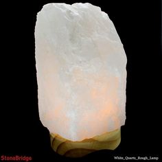 a large white rock sitting on top of a wooden stand next to a black background