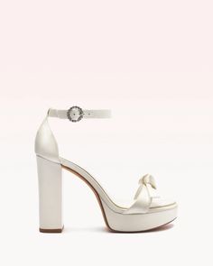 For the bride seeking an elevated lift, the Clarita Platform heel provides glamorous height with its 120mm block heel and platform, while remaining comfortable for day-to-night wear. Crafted in our light-reflected silver metallic leather, this eye-catching style is finished with our signature Clarita bow and an ankle-s Quince Heels, White Bridal Shoes, Wedding Shoes Platform, Wedding High Heels, White Platform Sandals, Latest Sandal, Wedding Shoes Bride, White High Heels, Beautiful High Heels