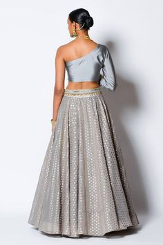 Grey lehenga in a chanderi silk base with woven floral motifs and embroidered waistband. Comes with embroidered one shoulder padded blouse.
Component: 2
Pattern: Woven and Embroidery
Type Of Work: Floral Motifs, Sequin and Pearl
Neckline: One Shoulder
Sleeve Type: Full Sleeves
Fabric: Chanderi Silk and Taffeta Silk
Color: Grey
Other Details: 
Blouse with sequin and pearl work
Closure: Side zip
Occasion: Destination Wedding - Aza Fashions Grey Lehenga, Pearl Work, Padded Blouse, Types Of Work, Luxury Sale, Silk Taffeta, Full Sleeves, Floral Motifs, Festival Wear