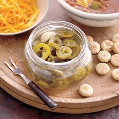 two bowls of soup and crackers on a cutting board