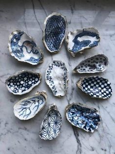 nine blue and white bowls sitting on top of a marble table