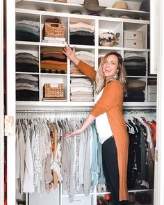 a woman standing in front of a closet full of clothes