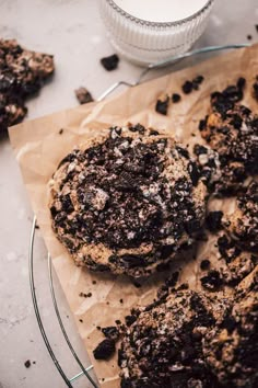 two cookies are sitting on a plate next to a glass container with some chocolate chips