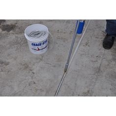 a bucket with a handle next to a blue and white mop on the ground