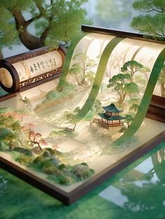 a paper model of a japanese landscape with trees and pagodas in the background, surrounded by green foliage