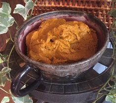 a bowl filled with food sitting on top of a table next to a basket full of leaves