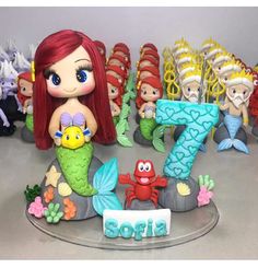 there are many little mermaid figurines on the table and one is number seven