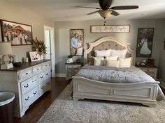 a bedroom with white furniture and pictures on the wall