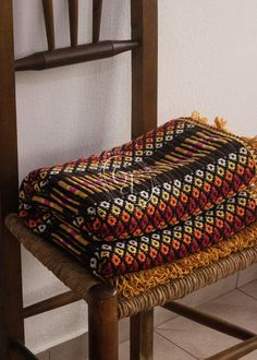 two blankets sitting on top of a wooden chair