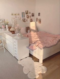 a bedroom with white furniture and pink sheets