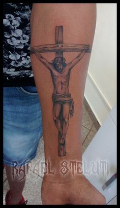 a man with a cross tattoo on his arm