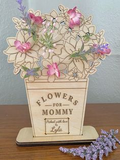 a flower pot with flowers in it sitting on a table next to some lavenders