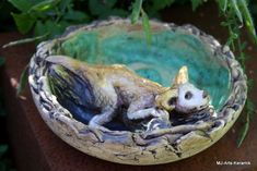 a small statue of a cat in a bowl